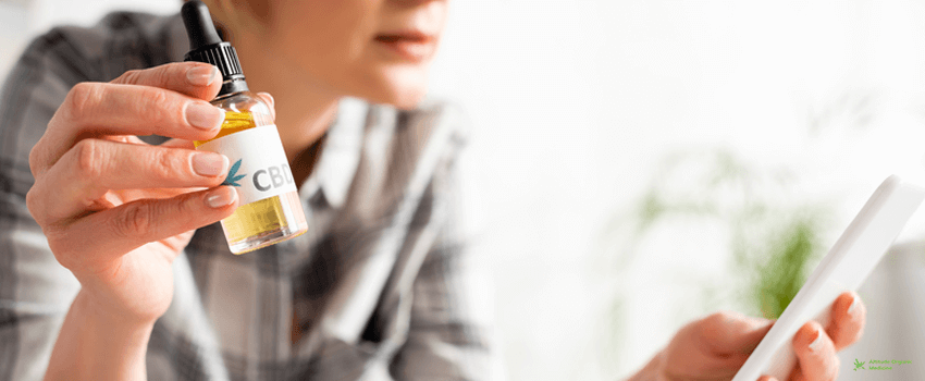AOC-View of mature woman holding bottle with cbd